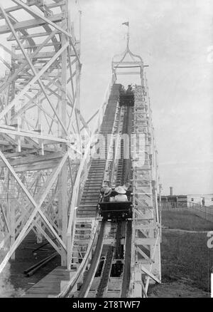 Blick auf die Achterbahnfahrt Wonderland, Auckland, Neuseeland-Ausstellung, Auckland, Neuseeland, Blick auf zwei Autoladen von Menschen auf dem ersten Abschnitt der Achterbahnfahrt „Wonderland Figur-8“. Kinder sind im Auto im Vordergrund zu sehen. CA. Dezember 1913 auf der Auckland, Neuseeland Ausstellung, Auckland, Neuseeland Domain Stockfoto