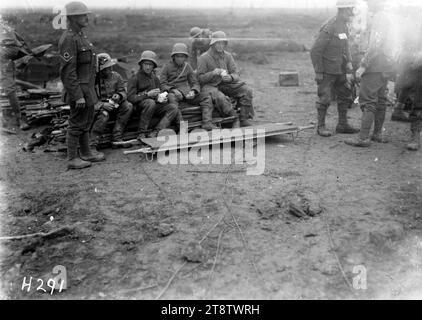 Gefangene deutscher Gefangener im Ersten Weltkrieg, Eine kleine Gruppe deutscher Gefangener, die am frühen Morgen mit neuseeländischen Soldaten in der Nähe saßen. Foto vom 4. Oktober 1917 Stockfoto