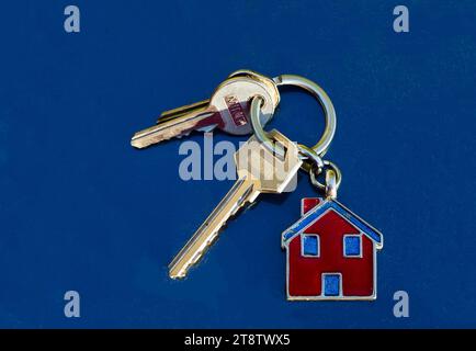 Hausschlüssel auf Schlüsselanhänger mit Hausbild auf der Fernbedienung Stockfoto