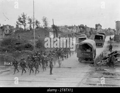 Ein neuseeländisches Bataillon, das durch das zurückeroberte Bapaume im Ersten Weltkrieg passiert, Eine allgemeine Ansicht der Truppen eines neuseeländischen Bataillons, die während des Ersten Weltkriegs auf einer Straße in zurückerobertem Bapaume entlang laufen Auf der anderen Straßenseite fahren Militärwagen. Ebenfalls sichtbar sind die Schäden an der Stadt selbst. Foto vom 14. September 1918 Stockfoto