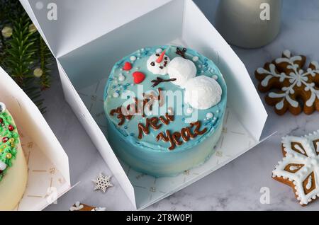 Weihnachtstorte, festlicher Schneemann-Bento-Kuchen, Neujahrsdessert auf hellem Hintergrund Stockfoto
