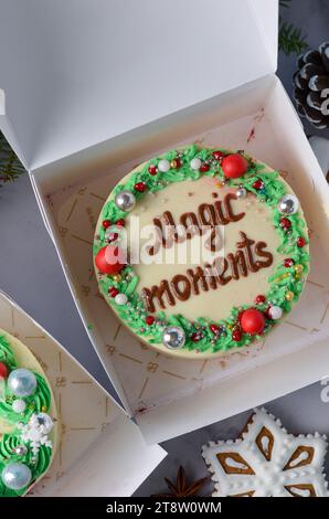 Weihnachtskuchen, festlicher Bento-Kuchen mit Gruß, Neujahrsdessert auf hellem Hintergrund Stockfoto