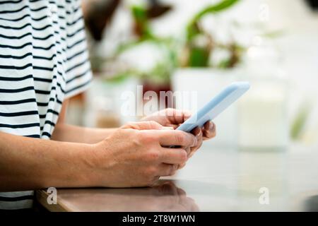 Nahaufnahme der Hände der erwachsenen Frau bei Verwendung des Smartphones Stockfoto