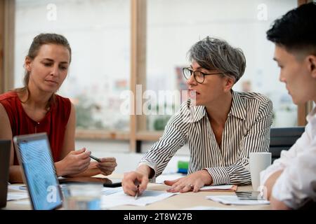 Geschäftsfrau diskutiert Projekt mit Kollegen Stockfoto