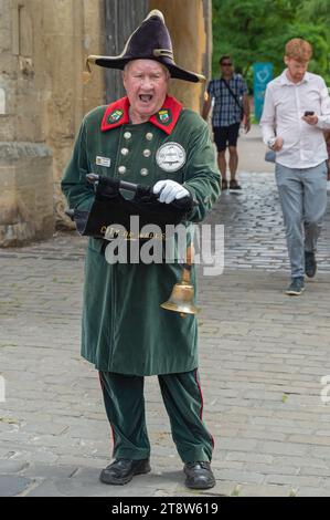 Der Town Crier läutet seine Glocke und macht eine Proklamation auf dem Market Square, Wells, Somerset, England, Großbritannien Stockfoto