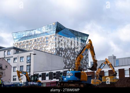 Bagger arbeiten in der Nähe der Mailbox, wo im Zuge der Entwicklung/Sanierung des Stadtzentrums Wohnhäuser im Bau sind, da am 3. November 2023 in Birmingham, Großbritannien, neue Blöcke in der Nähe der etablierten Turmblöcke am Holloway Circus entstehen. Die Stadt befindet sich in einer langfristigen und umfassenden Sanierung, wobei ein Großteil der industriellen Vergangenheit abgerissen und in neue Wohnungen für Wohnhäuser umgewandelt wird. Stockfoto