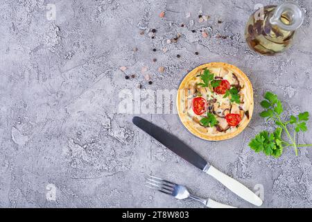 Köstliche Quiche mit Hühnerfleisch, Pilzen, Tomaten und Kräutern Stockfoto