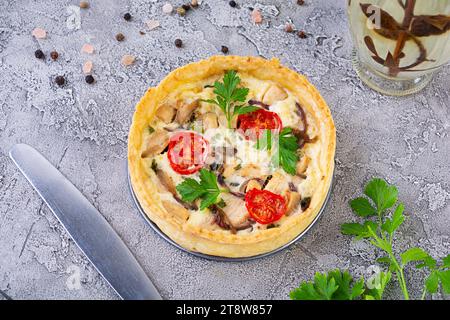 Köstliche Quiche mit Hühnerfleisch, Pilzen, Tomaten und Kräutern Stockfoto