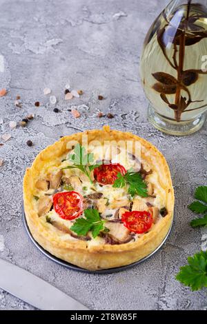 Köstliche Quiche mit Hühnerfleisch, Pilzen, Tomaten und Kräutern Stockfoto