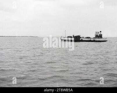 1950er Jahre, historisch, am Fluss Severn, eine kleine dampfbetriebene Autofähre, die Severn Queen, mit Fahrzeugen an Bord, England, Großbritannien. Die Severn Queen-Autofähre wurde 1934 auf den Markt gebracht und konnte nur 17 Autos transportieren. Mit der Eröffnung der Severn Bridge im Jahr 1968 wurde die Fähre für Geschäftszwecke geschlossen. Stockfoto