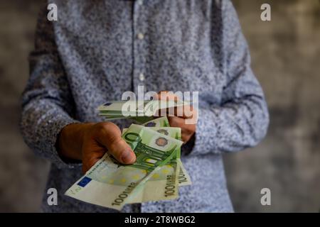 Konkurs Geld ohne Grenzen ausgeben Schulden Steuern Euro in den Händen eines Mannes Stockfoto