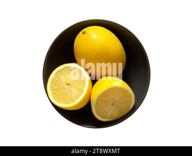 Zitronen ganz und in grauer Schüssel geschnitten, isoliert auf weißem Hintergrund mit Beschneidungspfad. Stockfoto