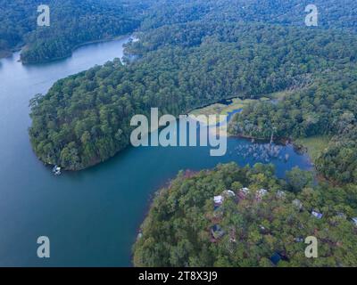 Aus der Vogelperspektive auf dem Tuyen Lam See in Dalat, Vietnam, wunderschöne Landschaft für Öko-Reisen in Vietnam, fantastischer See zwischen Kiefernwäldern, Boot auf Wasser Stockfoto