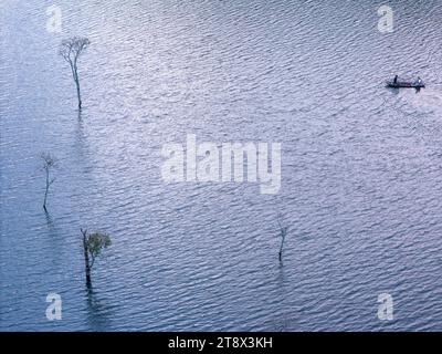 Aus der Vogelperspektive auf dem Tuyen Lam See in Dalat, Vietnam, wunderschöne Landschaft für Öko-Reisen in Vietnam, fantastischer See zwischen Kiefernwäldern, Boot auf Wasser Stockfoto