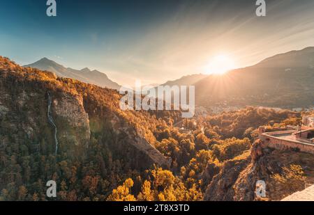 Wunderschöner Sonnenuntergang über der alten historischen Stadt Briancon mit Herbstwald und Wasserfall zwischen den französischen Alpen in Hautes Alpes, Frankreich Stockfoto