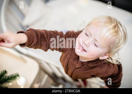 Porträt eines entzückenden kleinen Mädchens, das zu Hause mit weihnachtsdekoration spielt Stockfoto