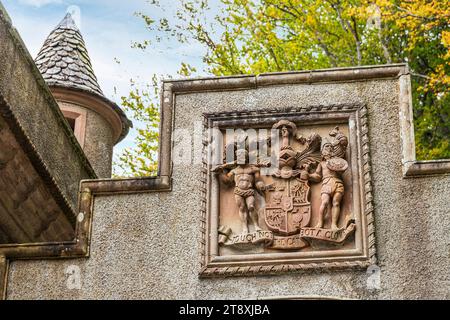 Das Motto des Clans Macpherson „Touch Not the Cat Bot A Glove“ auf einer Lodge zum Ballindalloch Castle neben dem Fluss Avon bei Bridge of Avon, Speyside, Stockfoto