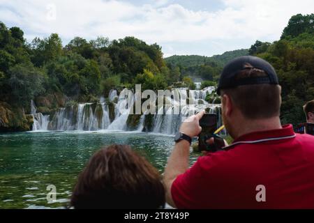 Touristen fotografieren den Skradinski Buk Wasserfall im Krka Nationalpark, Lozovac, Kroatien. September 2023. Stockfoto