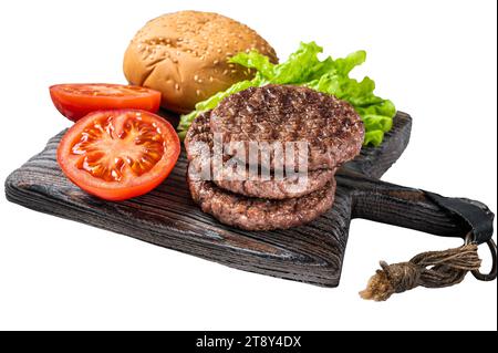 Gebratenes Schnitzel für Burger mit Gemüse und Gewürzen auf Holzbrett isoliert, weißer Hintergrund Stockfoto
