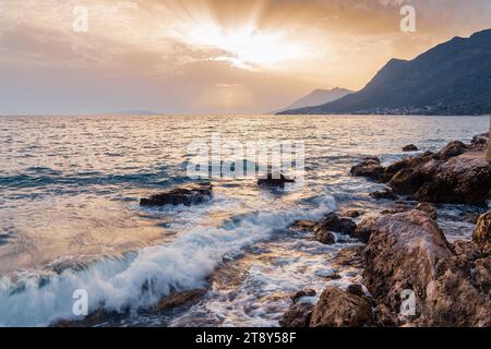 Sonnenuntergang über dem Meer, Wellen krachen an die Küste Stockfoto