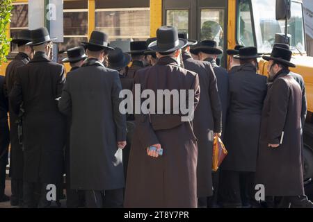 Eine große Gruppe ultraorthodoxer Satmar-Juden aus Williamsburg steigen in einen Bus, um zu einem Talmud-Seminartag in einem anderen Stadtteil zu fahren. November 2023. Stockfoto