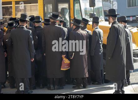 Eine große Gruppe ultraorthodoxer Satmar-Juden aus Williamsburg steigen in einen Bus, um zu einem Talmud-Seminartag in einem anderen Stadtteil zu fahren. November 2023. Stockfoto