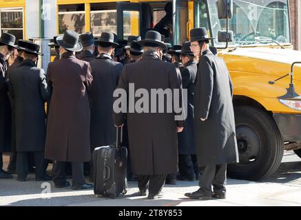 Eine große Gruppe ultraorthodoxer Satmar-Juden aus Williamsburg steigen in einen Bus, um zu einem Talmud-Seminartag in einem anderen Stadtteil zu fahren. November 2023. Stockfoto