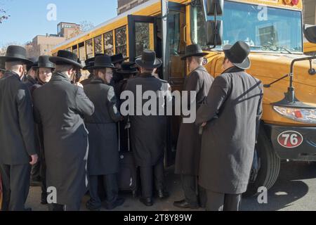 Eine große Gruppe ultraorthodoxer Satmar-Juden aus Williamsburg steigen in einen Bus, um zu einem Talmud-Seminartag in einem anderen Stadtteil zu fahren. November 2023. Stockfoto