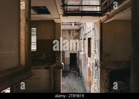 Verlassenes, beschädigtes Innengebäude mit zerfallenden Ziegelmauern und Trümmern Stockfoto