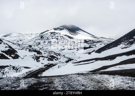 Krater des Vulkans Ätna im Winter, Sizilien Insel, Italien. Landschaft der Silvestri-Krater mit schwarzen vulkanischen Lavasteinen. Aktive Vulkanhänge Stockfoto