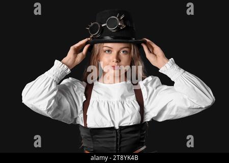 Junge Frau mit Steampunk-Brille auf dunklem Hintergrund Stockfoto