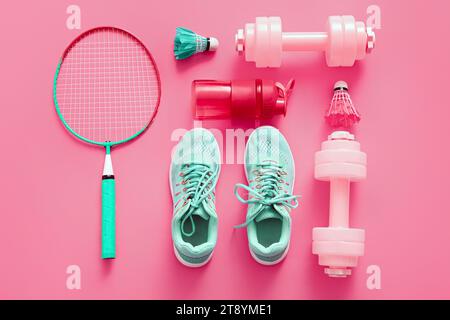 Komposition mit verschiedenen Sportgeräten und Schuhen auf rosa Hintergrund Stockfoto