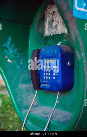 Altes blaues öffentliches Telefon (Münztelefon). Texturhintergrund eines alten, nicht funktionierenden Eisenstraßentelefons mit Knöpfen Stockfoto