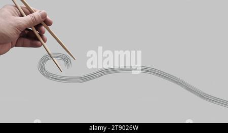 Asiatische Bambus-Essstäbchen in einer Hand auf monochromem Hintergrund gehalten. Kein Essen. Keine identifizierbare Person. Fotobearbeitung. Kopierbereich Stockfoto