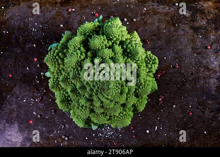 Romanesco-Kohl auf Backblech mit Kräutern, Blick von oben und dunkles Ambiente Stockfoto