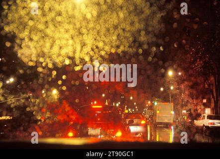 Nachts im Regen fahren. Rückleuchten und Regentropfen reflektieren auf der Windschutzscheibe oder der Windschutzscheibe im Fahrzeuginnenraum. Beleuchtung. Fahren Sie Midtown Manhattan, NYC Stockfoto