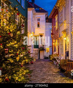Weihnachtsdekoration zwischen alten Holzhäusern in einer engen Straße in Bergen, Norwegen. Stockfoto