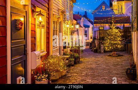 Weihnachtsdekoration im Freien zwischen alten Holzhäusern in einer engen Straße in Bergen, Norwegen. Stockfoto