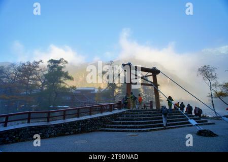 KAMIKOCHI, NAGANO, JAPAN-Touristen auf der Kappa Holzbrücke im Kamikochi Nationalpark, dem nördlichen Teil der Japanischen Alpen Stockfoto