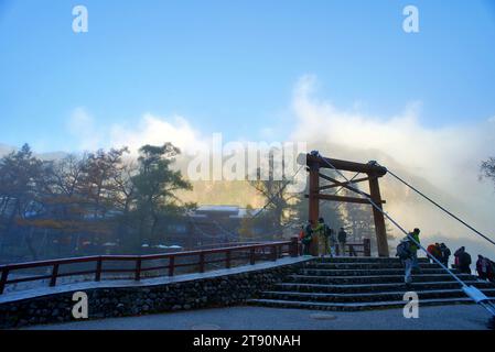KAMIKOCHI, NAGANO, JAPAN-Touristen auf der Kappa Holzbrücke im Kamikochi Nationalpark, dem nördlichen Teil der Japanischen Alpen Stockfoto