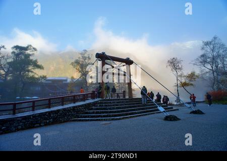 KAMIKOCHI, NAGANO, JAPAN-Touristen auf der Kappa Holzbrücke im Kamikochi Nationalpark, dem nördlichen Teil der Japanischen Alpen Stockfoto