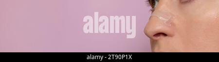 Banner Closeup Nasenstreifen auf weiblicher Nase auf rosa Hintergrund. Klebebandage für bessere Atmung. Stoppen Sie Die Medikamentöse Schnarchlösung. Speicherplatz Kopieren Für Stockfoto