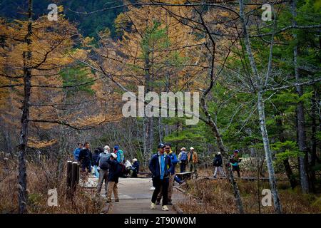KAMIKOCHI, NAGANO, JAPAN-Touristen auf der Kappa Holzbrücke im Kamikochi Nationalpark, dem nördlichen Teil der Japanischen Alpen Stockfoto