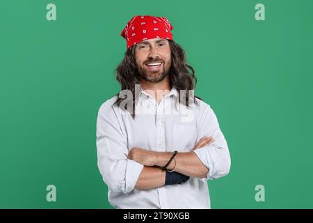 Stilvoller Hippie-Mann in weißem Hemd auf grünem Hintergrund Stockfoto