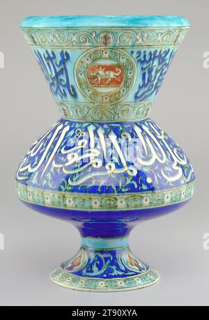 Vase in Form einer Moscheelampe, um 1870, Joseph-Théodore Deck, Französisch, 1823-1891, 1/4 x 10 x 10 Zoll (36,2 x 25,4 x 25,4 cm), verzinntes Steingut, Frankreich, 19. Jahrhundert, Théodore Deck's Interesse und Können an der Reproduktion traditioneller persischer Designs und Farben wird mit dieser Vase gesehen. Es ist mit arabischen Schriften und der lebhaften türkisblauen Farbe dekoriert, die oft mit Isnik-Waren assoziiert wird. Tatsächlich ist die Form dieser Vase von islamischen Moscheelampen inspiriert, die im 14. Jahrhundert in Syrien und Ägypten hergestellt wurden. Antike Objekte und Motive aus dem Nahen Osten erwiesen sich als beliebte Quellen Stockfoto