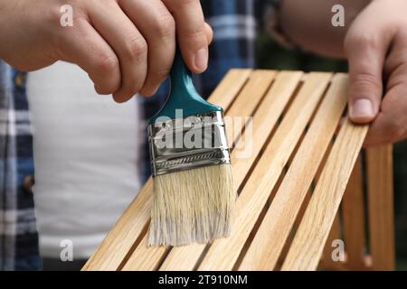 Mann, der Lack auf Holzkiste aufträgt, Nahaufnahme Stockfoto