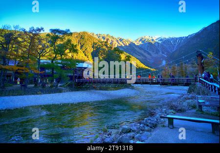 KAMIKOCHI, NAGANO, JAPAN-Touristen auf der Kappa Holzbrücke im Kamikochi Nationalpark, dem nördlichen Teil der Japanischen Alpen Stockfoto