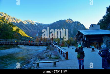 KAMIKOCHI, NAGANO, JAPAN-Touristen auf der Kappa Holzbrücke im Kamikochi Nationalpark, dem nördlichen Teil der Japanischen Alpen Stockfoto
