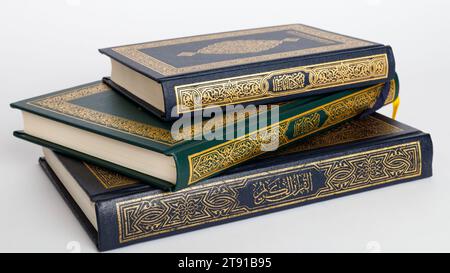 Eine Reihe heiliger koranbücher in verschiedenen Größen, isoliert auf weißem Hintergrund. Seitenansicht. Stockfoto