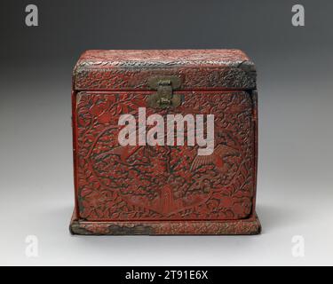 Kosmetikschrank, 16. Jahrhundert, 12 1/8 x 13 3/8 x 9 1/2 Zoll (30,8 x 33,97 x 24,13 cm), geschnitzter roter Lack auf einem Weichholzrahmen, China, 16. Jahrhundert, eine gravierte und vergoldete Markierung auf der Basis dieser Tischplatte sagt uns, dass es ein Produkt der offiziellen Werkstätten der Jiajing-Ära der Ming-Dynastie ist, es stammt aus der Mitte der 1500er Jahre Diese Box zeigt ein reich orchestriertes Schema symbolischer Pflanzen und Tiere. Die Kartuschen oben und an den Seiten zeigen den verheißungsvollen phönix und die Kraniche zwischen Wolken. Auch Symbole für langes Leben erscheinen – der Shou-Charakter (Langlebigkeit) Stockfoto